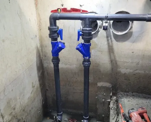 Installation de plomberie avec vannes et tuyaux bleus.