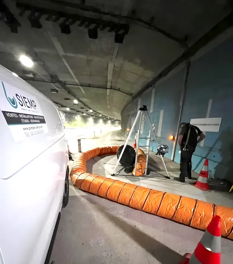 Travaux dans un tunnel avec équipement de ventilation.